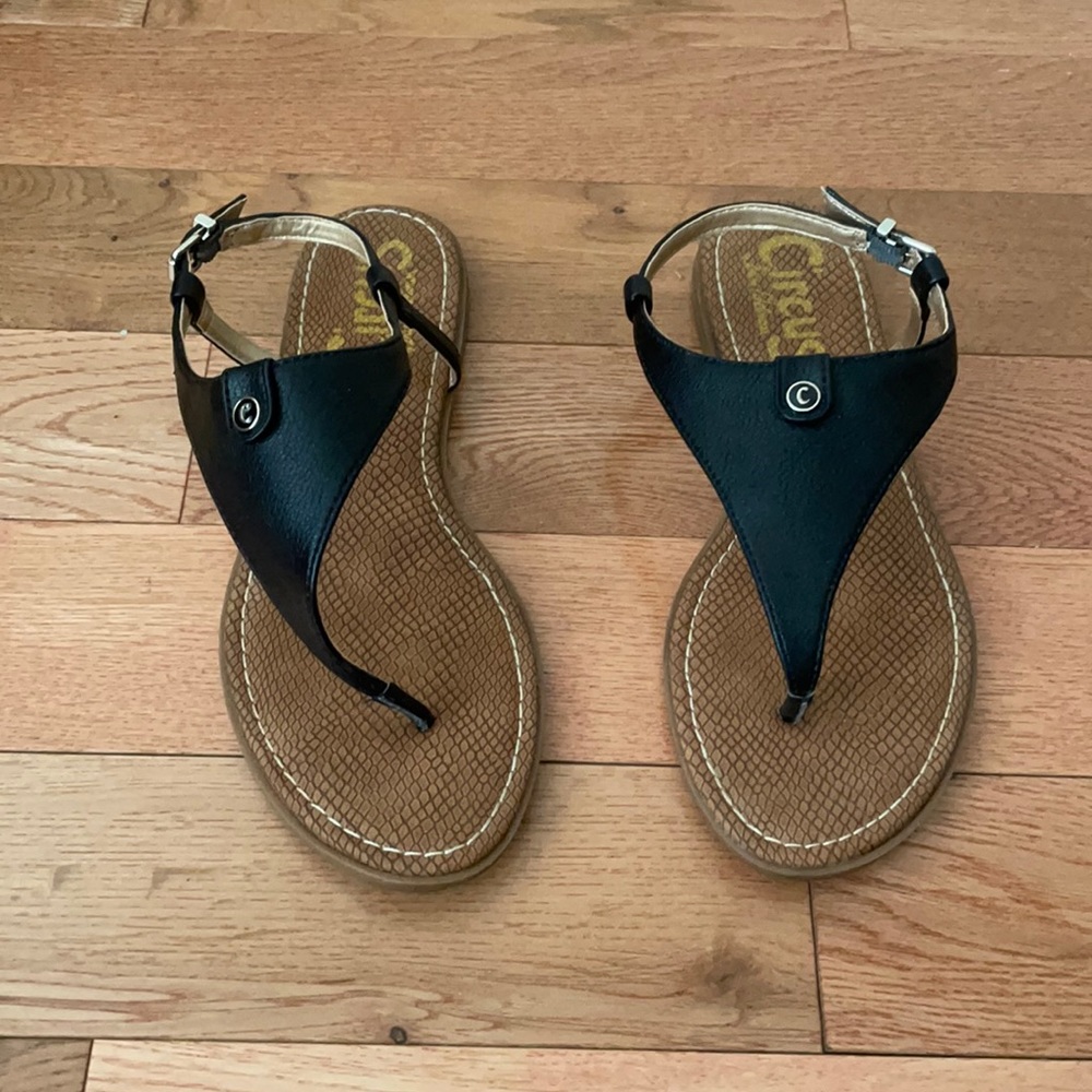 Black, faux leather sandals with adjustable strap.
